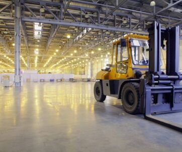 A clean, organized warehouse with a forklift parked inside, showcasing a spacious and well-maintained industrial environment.