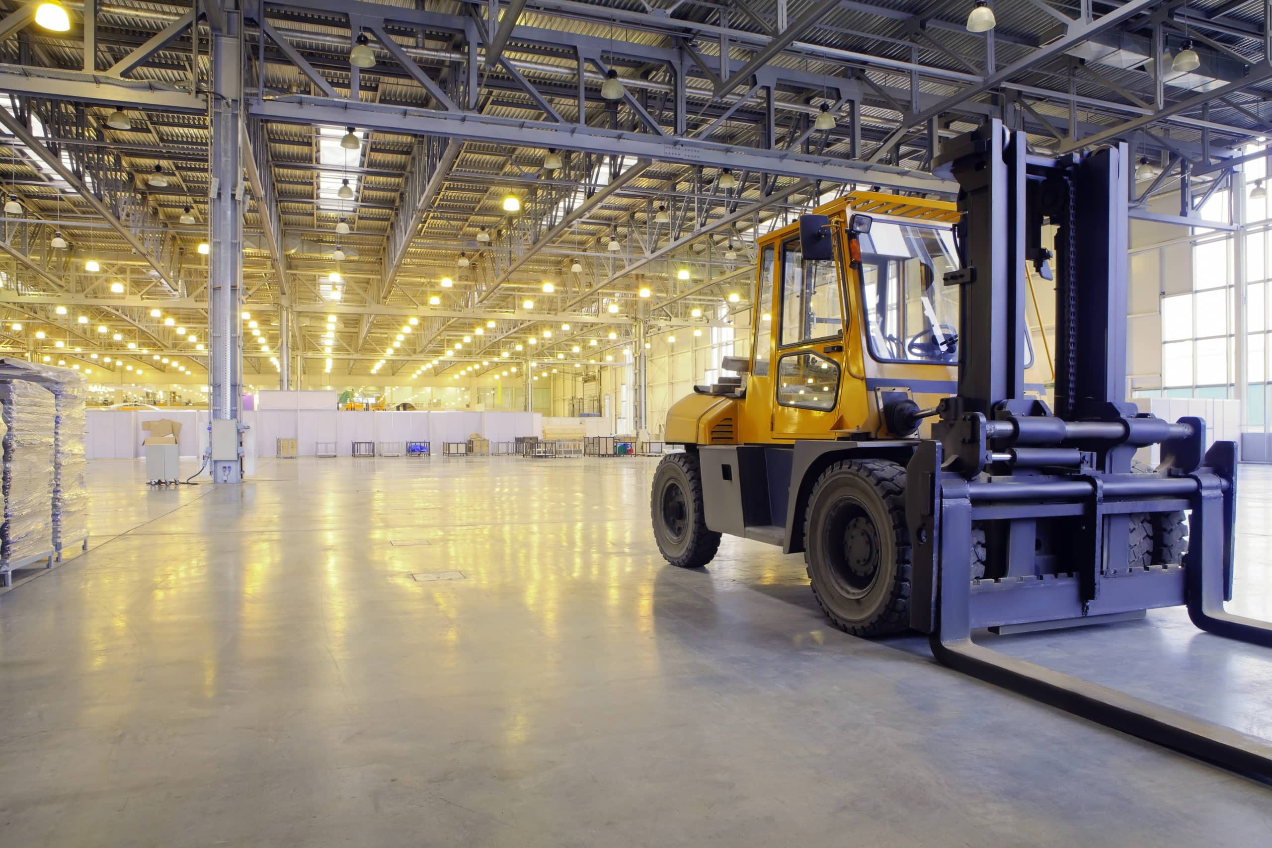 A clean, organized warehouse with a forklift parked inside, showcasing a spacious and well-maintained industrial environment.