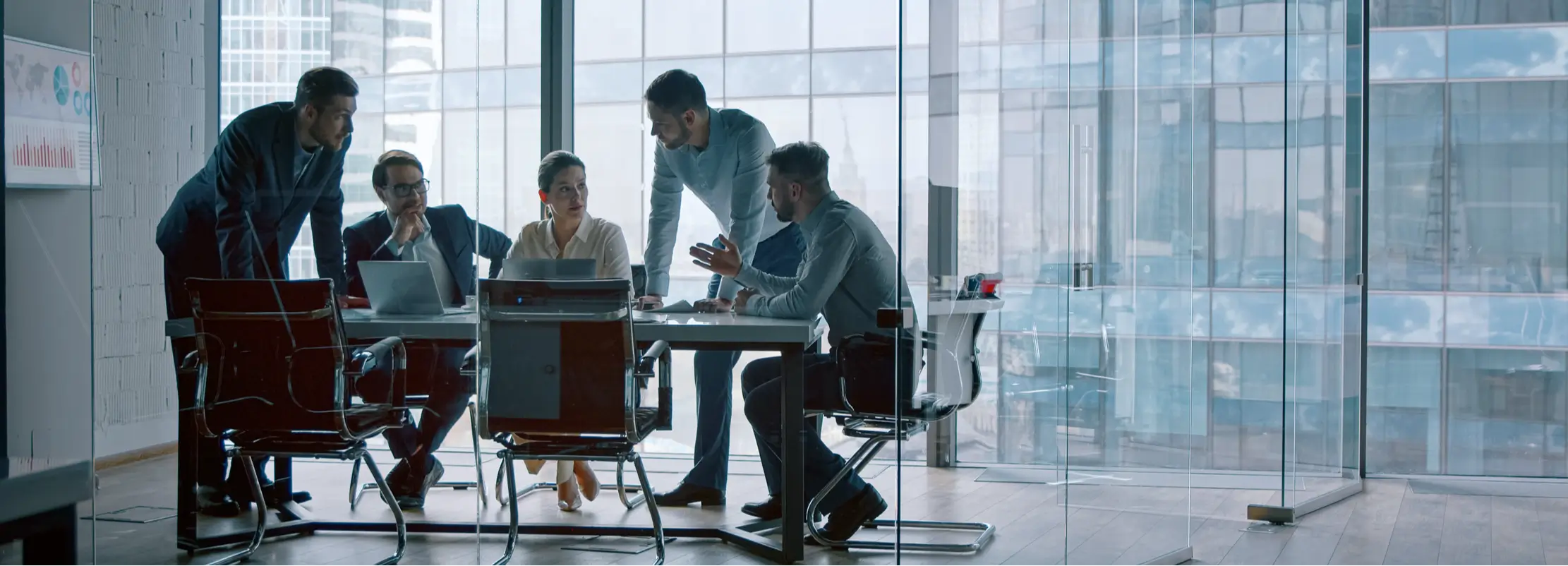Five men and one woman conduct a strategy and operations consulting meeting at a small conference table.