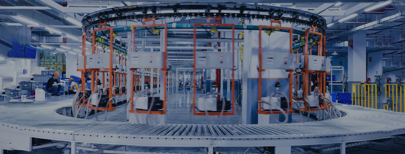 Automated conveyor system with machinery in a modern industrial facility; workers are present in the background.