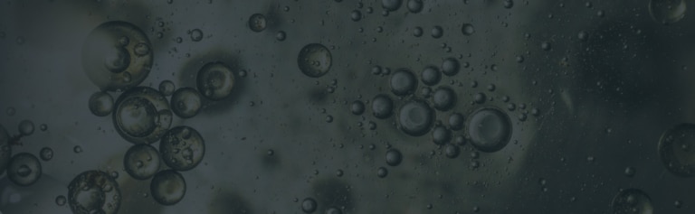 Clusters of round bubbles of various sizes suspended in a dark, liquid-like substance.