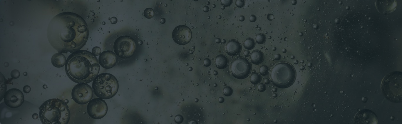 Clusters of round bubbles of various sizes suspended in a dark, liquid-like substance.