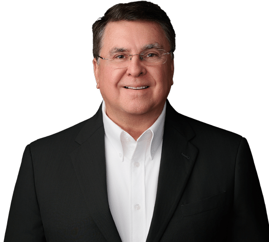 A middle-aged man wearing glasses, a white dress shirt, and a dark suit jacket, smiling against a plain light background.