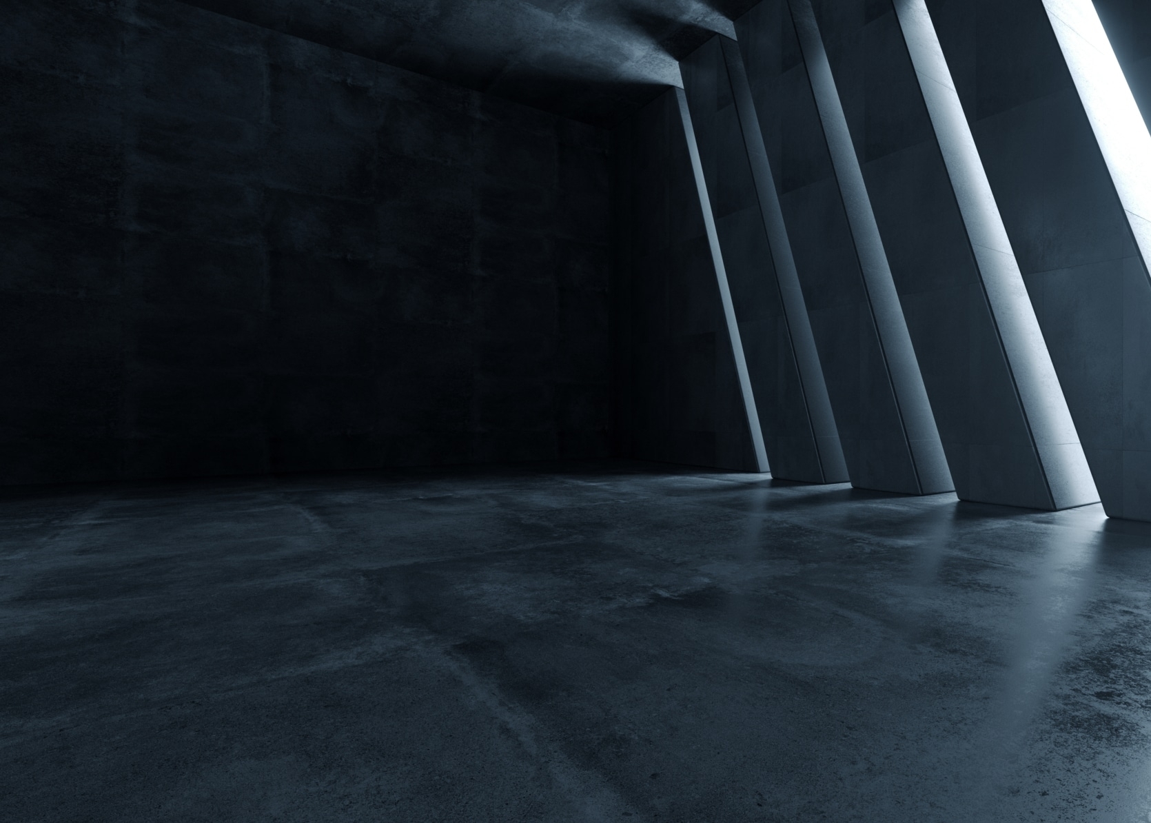Dark, empty room with a concrete floor and angled vertical windows on one side, allowing bright light to enter and cast shadows across the space.