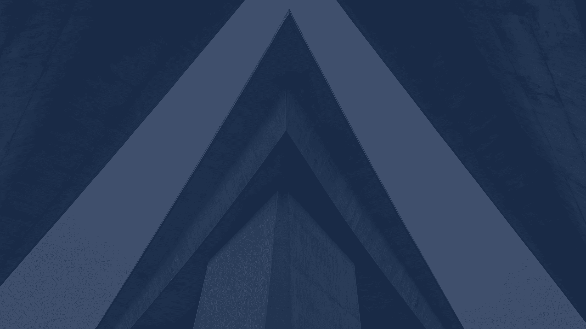 Abstract architectural image showing a low-angle view of intersecting concrete beams forming sharp geometric lines against a dark background.