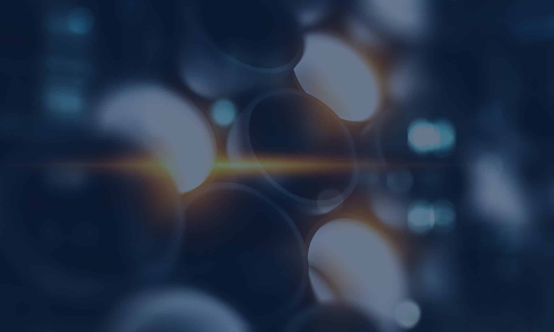 Abstract image of blurred circular shapes with a central light flare and a blue color palette.
